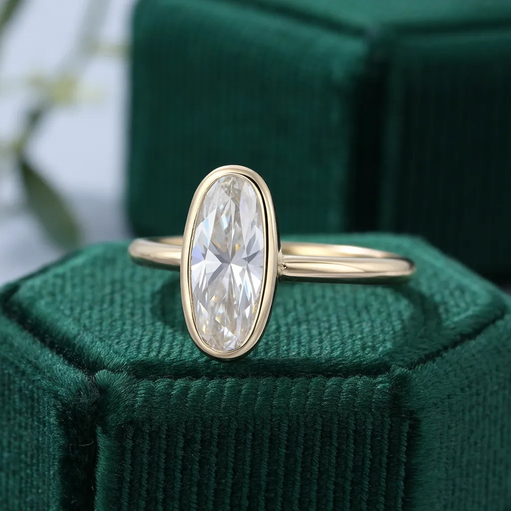 Elongated oval diamond in a gold bezel engagement ring, design preview